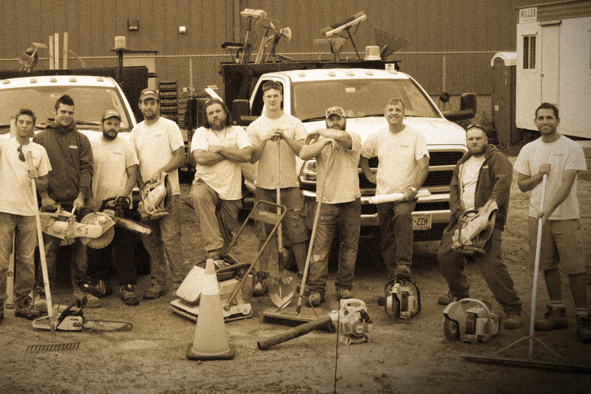 group of men with trucks and tools in a shop yard